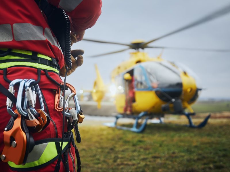 Paramedic of emergency service in front of helicopter