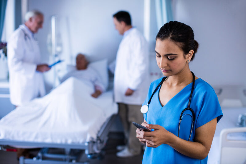 Female,Doctor,Talking,On,A,Mobile,Phone,In,The,Ward