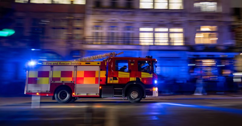 Fast moving,Fire,Truck,With,Sirens,On,,Racing,Through,Downtown,Streets