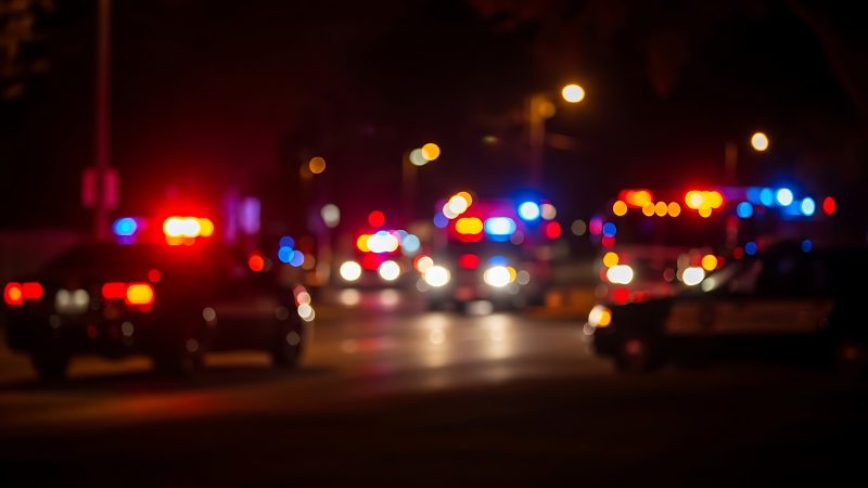 A,Blurred,Night,Scene,Featuring,Multiple,Emergency,Vehicles,,Primarily,Police